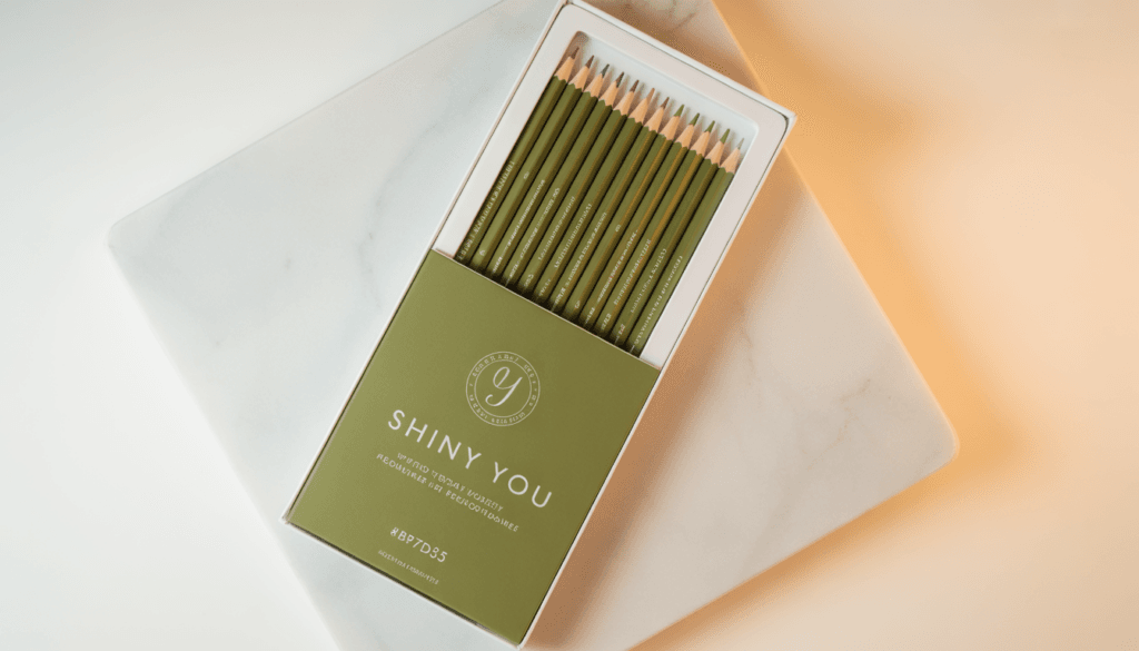 Shiny You branded pencil set with multiple pencil lead grades displayed on a white marble surface